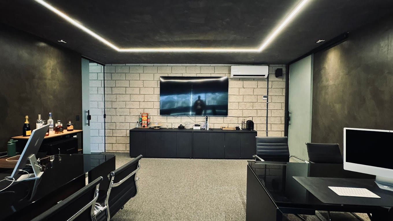 Sala de atendimento da DUO MOTORS, com mesas escuras e iluminação em linha no teto